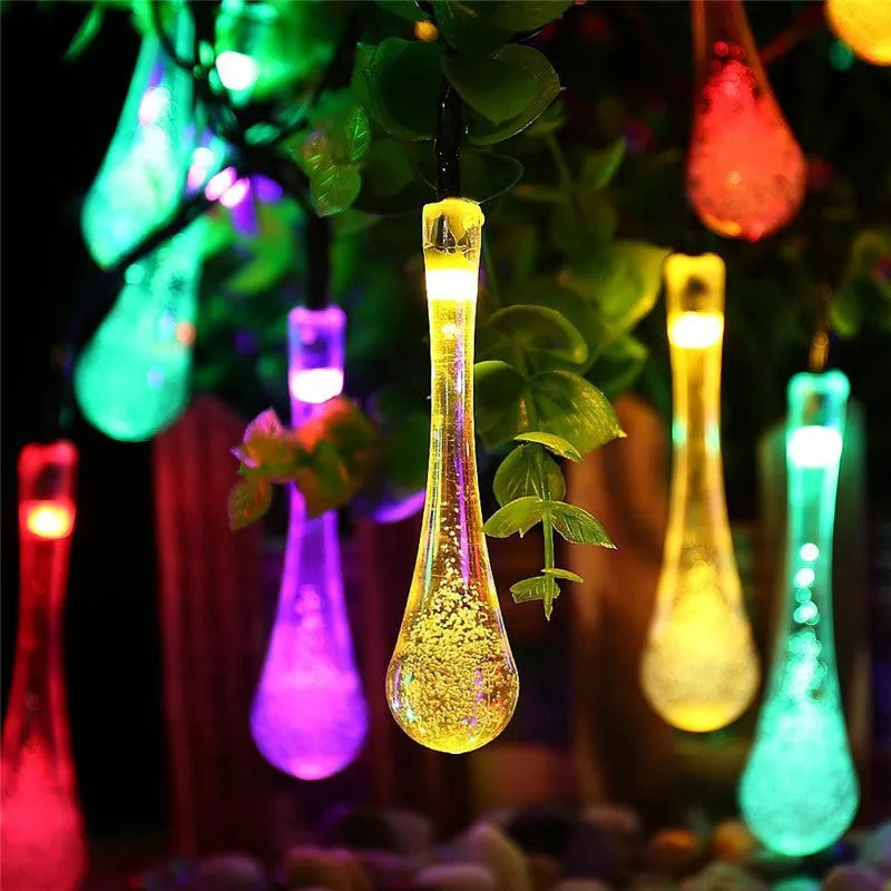 6.5 metre solar LED outdoor string lights with water drop bubble pendants in garden setting