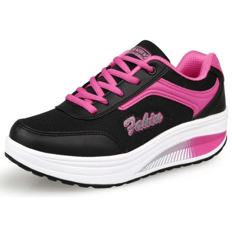 Women's grey and pink sports shoes with a middle heel on a plain background