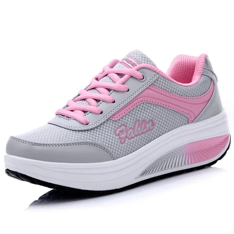 Women's grey and pink sports shoes with a middle heel on a plain background