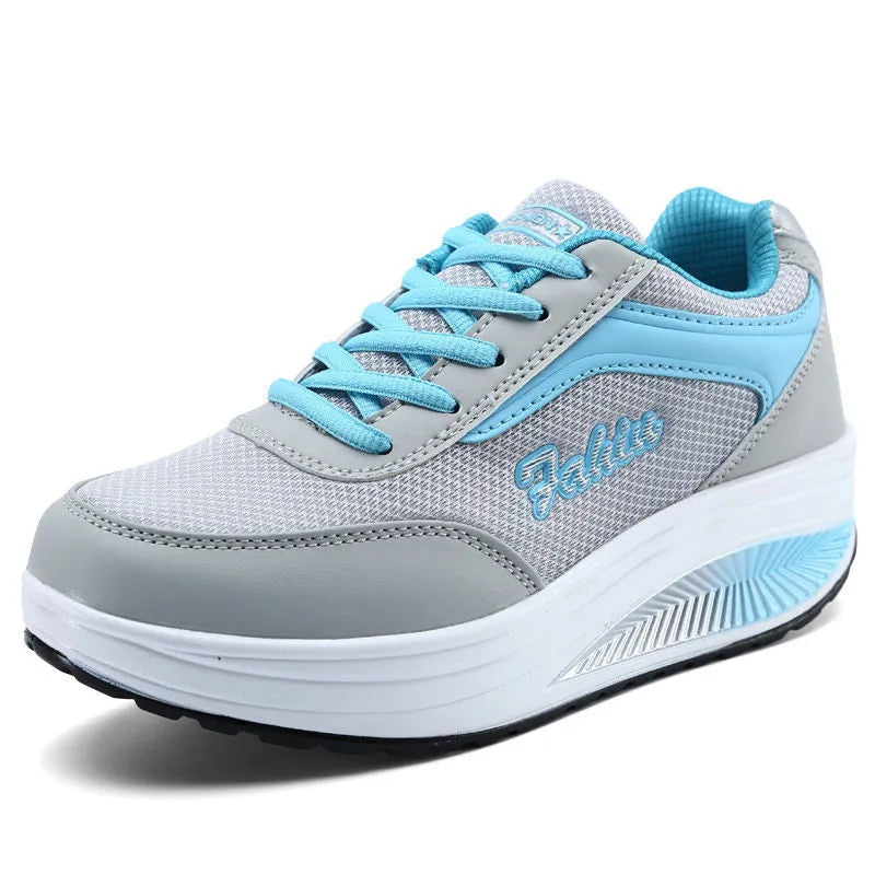 Women's grey and pink sports shoes with a middle heel on a plain background