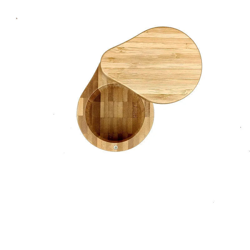 Bamboo seasoning storage box with a matching bamboo spoon on a kitchen counter.