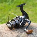 Telescopic fishing rod combo with carbon fibre rod and spinning reel with solid wood handle on a beach