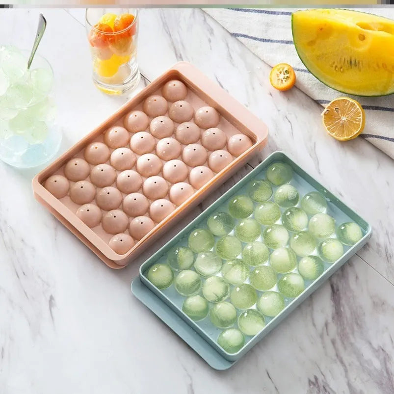 Sky blue and pink 3D round ice cube mould trays showing spherical cavities.