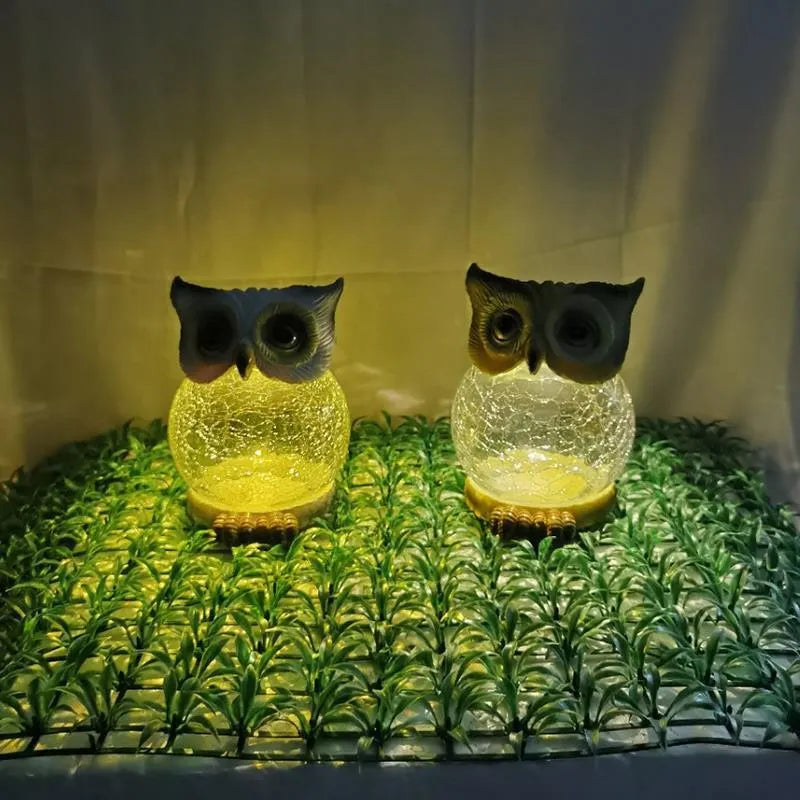 White solar powered LED owl shaped outdoor light on a garden patio.
