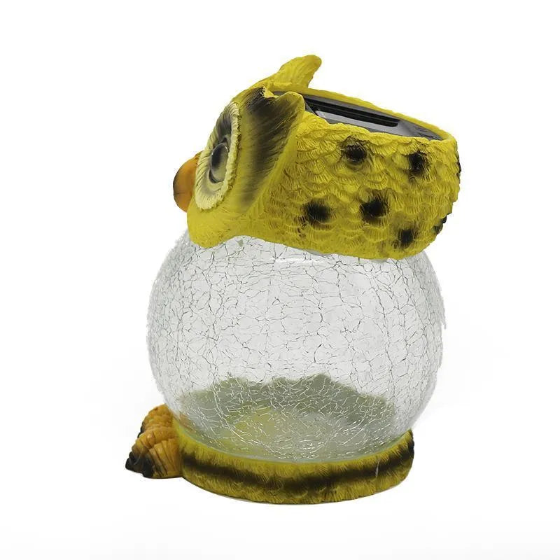 White solar powered LED owl shaped outdoor light on a garden patio.