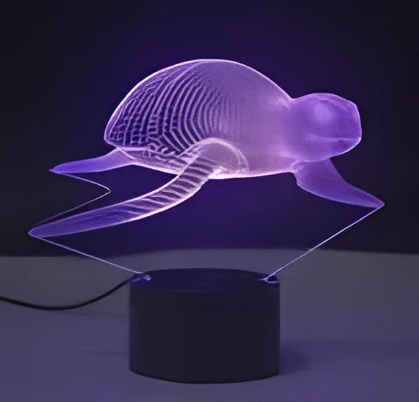Small black-based 3D acrylic LED table lamp showing colourful gradient light effect on a desk.