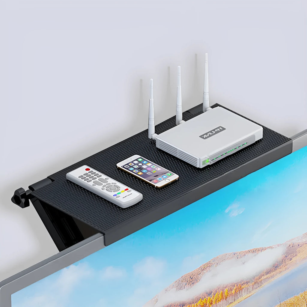 Plastic desktop storage rack holding a TV set-top box and router, showing cable routing through its free punching design.