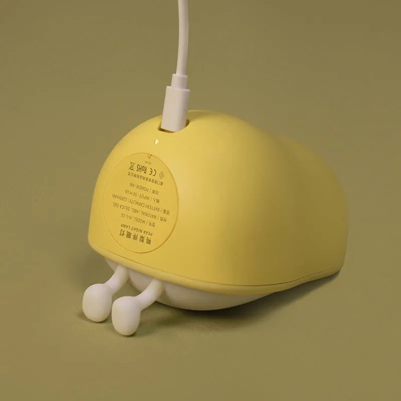 Pear-shaped silicone bedside night lamp with warm yellow glow and compact design