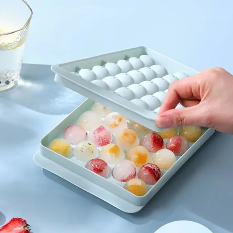Silicone ice cube tray with lid in blue or pink, showing 33 round ice moulds measuring 24x14 cm.