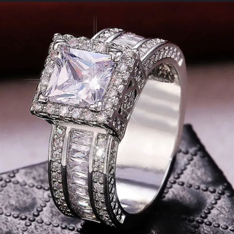 Geometric women's silver fashion ring with round details in gold or white electroplated finish on a finger.