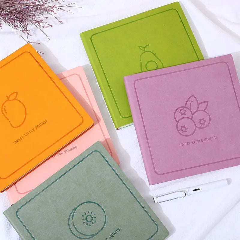 Square faux leather notebook in peach pink, avocado green, or grey green with blank, lined, or grid pages.