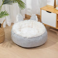 Blue plush faux fur circular cat bed with raised sides on a wooden floor