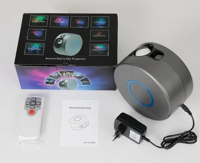 Grey starry sky projection lamp with remote control on a table, projecting light onto a ceiling.