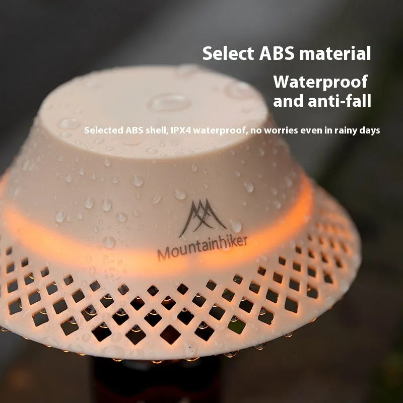 Beige and grey wine bottle-shaped camping lantern with USB-C port on a wooden table.