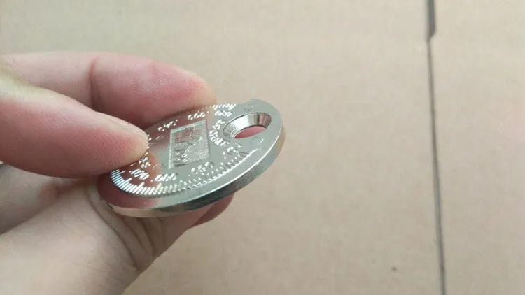 Round zinc alloy spark plug gauge with dual scales on a white background
