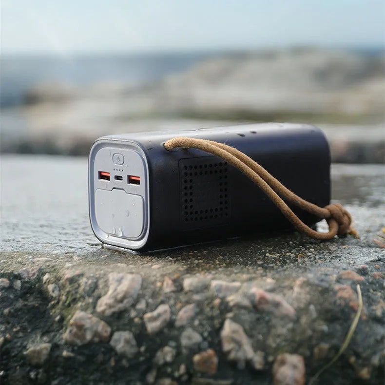 Black portable power bank with digital display, showing solar panel and car charging cables.