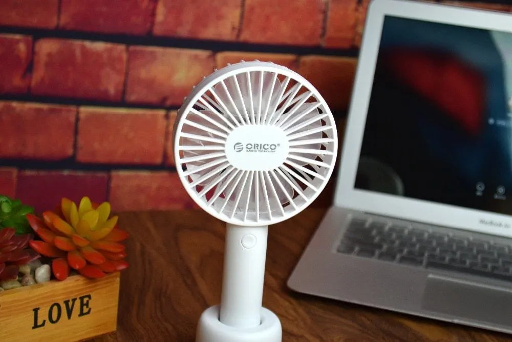 White ORICO FH1 portable USB rechargeable desk and handheld fan on a table