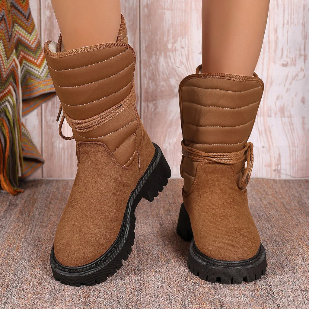 Black women's high-top suede snow boots with chunky rubber sole and lace-up design