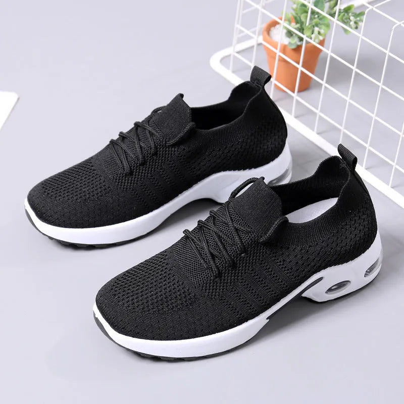 Women's black mesh lace-up sneakers with a round toe and soft sole on a white background.