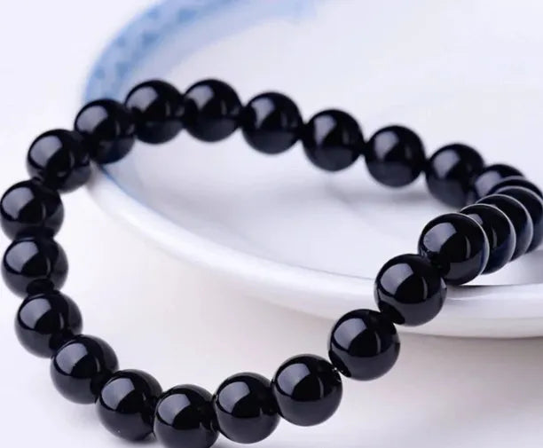 Black agate geometric bracelet with 8mm beads on a black elastic cord.