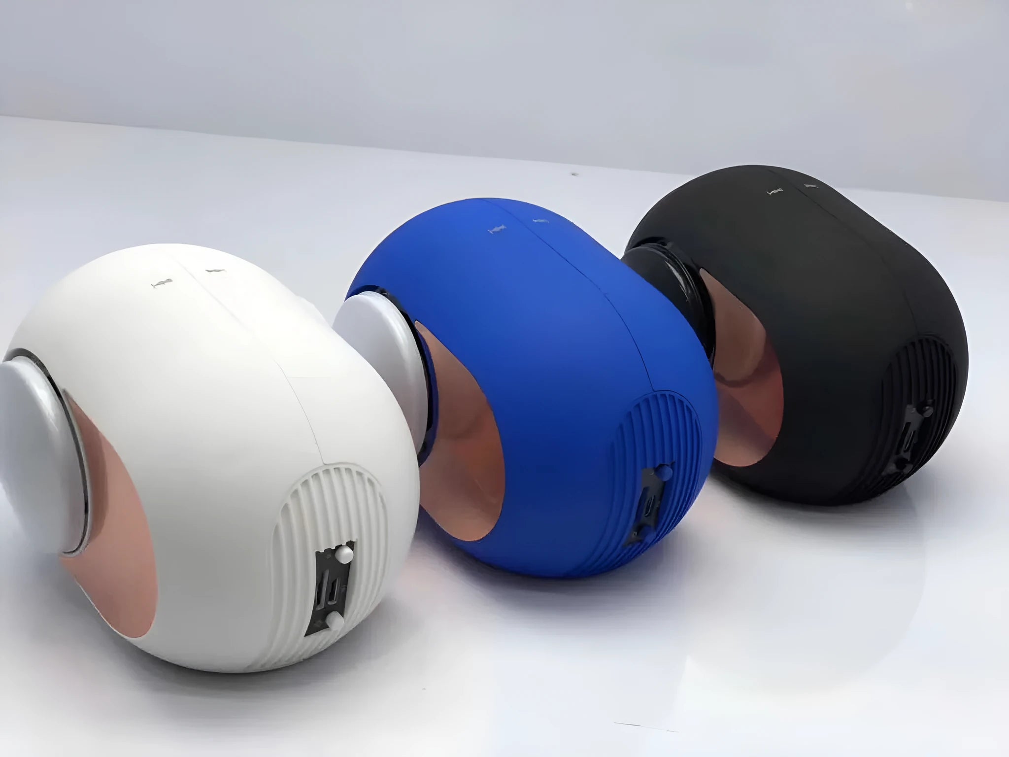 Small golden egg-shaped wireless Bluetooth speaker in black, white, or blue colour with charging cable.