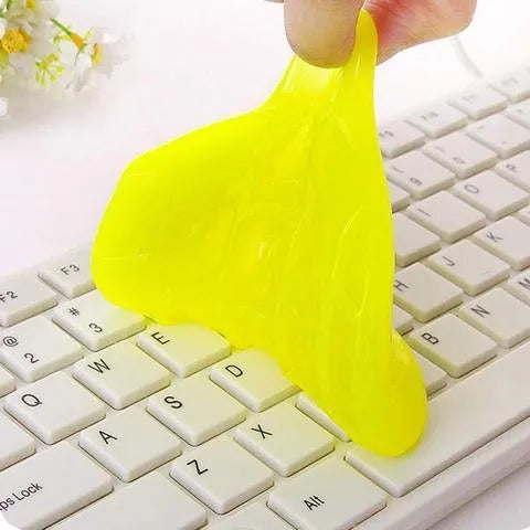 Blue and yellow magic cleaning gel putty for dust removal on a keyboard