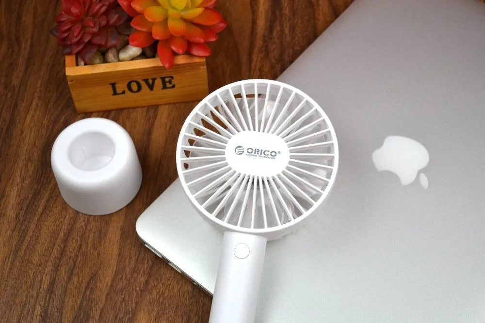 White ORICO FH1 portable USB rechargeable desk and handheld fan on a table