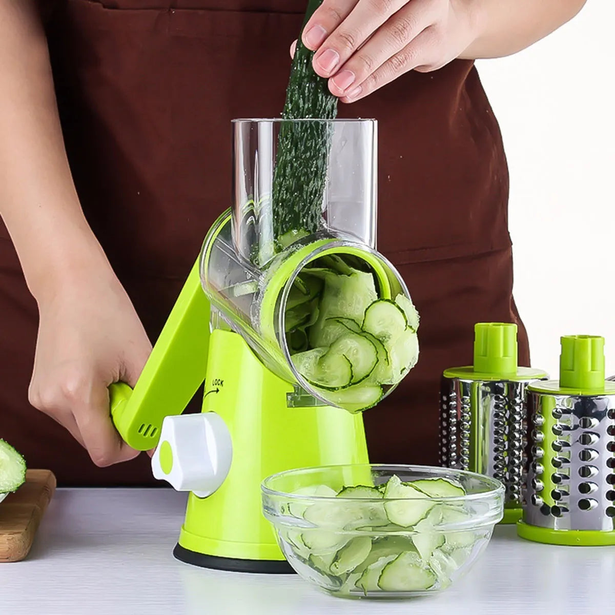 Round mandoline slicer with three stainless steel blades and a suction base in blue green, green, or red