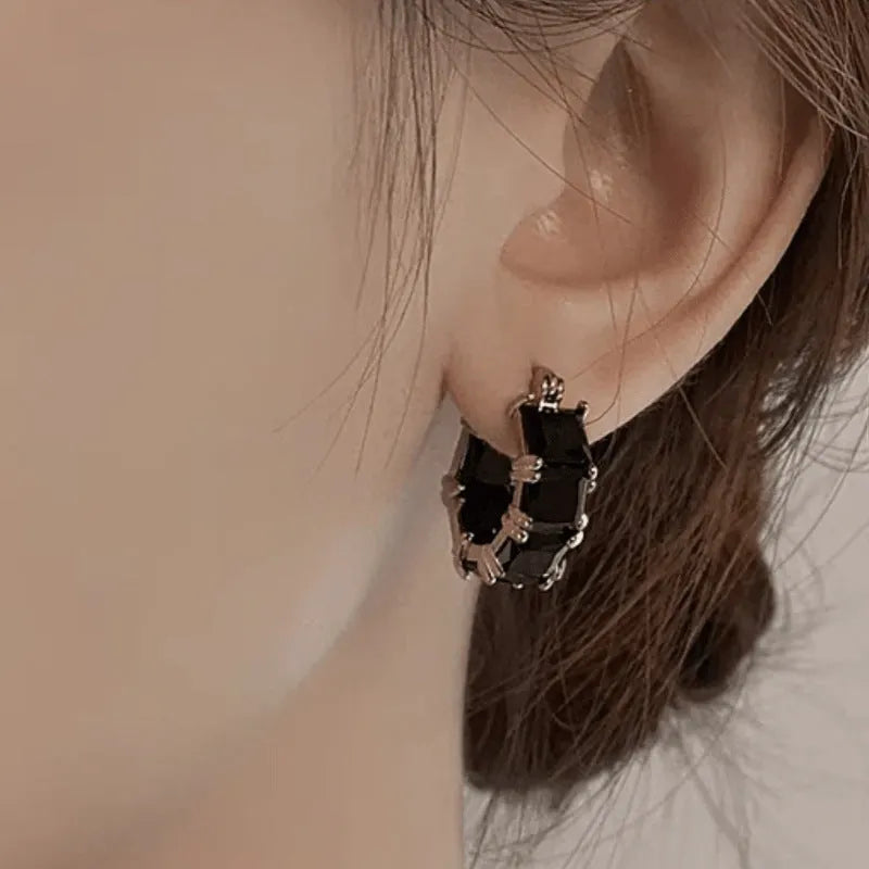Women's geometric U-shaped earrings with round black zirconium stones and gold electroplated copper construction