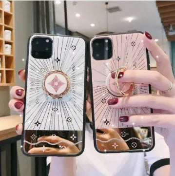 Rose gold and white gold iPhone ring stands with a diamond accent on a phone back.