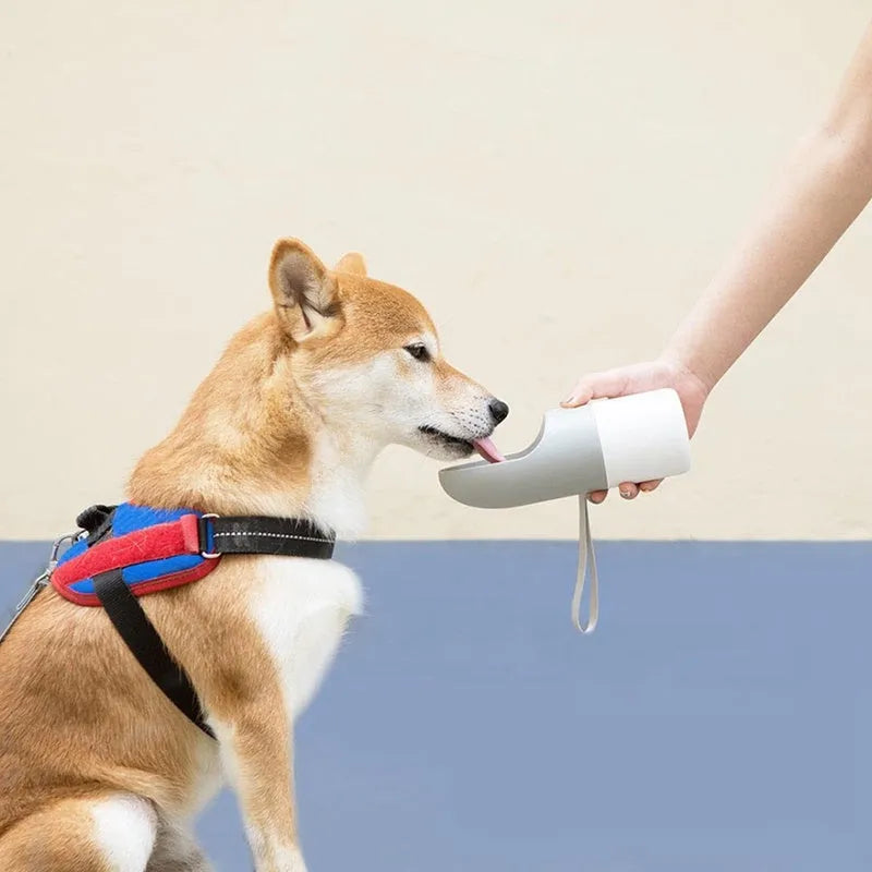 MOESTAR white and grey rocket-shaped pet drinking cup with a black drinking nozzle and lock button.