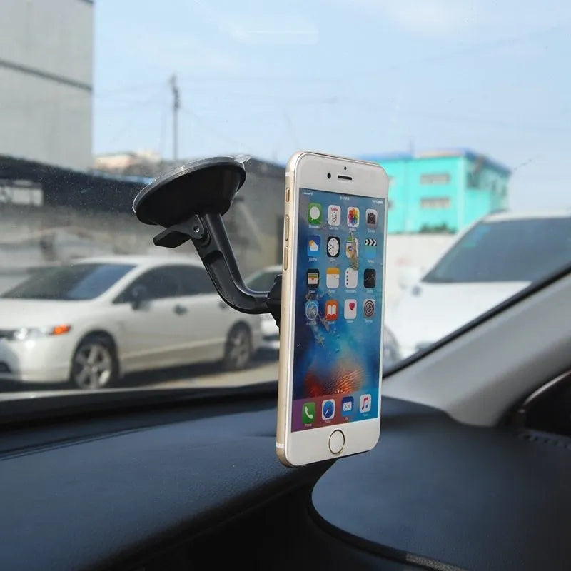Black magnetic car phone holder with 360-degree rotating bracket mounted on a car dashboard.
