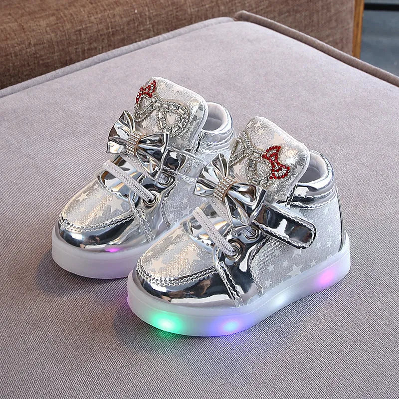 Golden children's LED sneakers with a light-up magic button on the heel