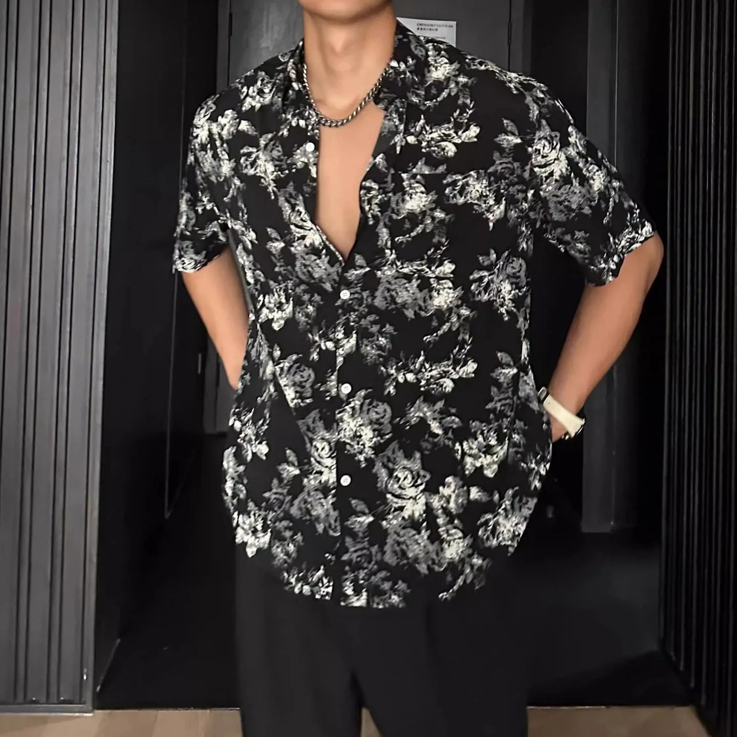 Black and white loose-fit floral printed short sleeve casual shirt on a hanger.
