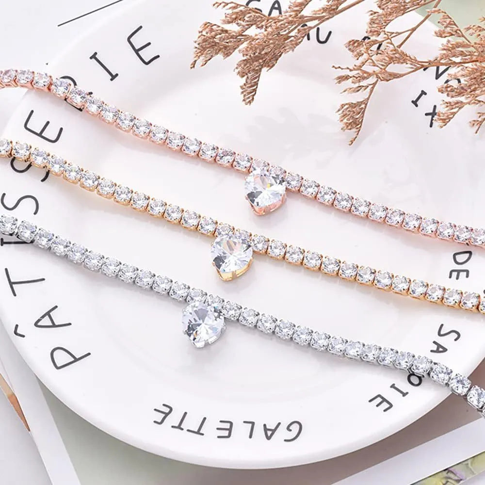 Gold heart-shaped rhinestone dog collar on a white background, showing shiny crystals and adjustable clasp.