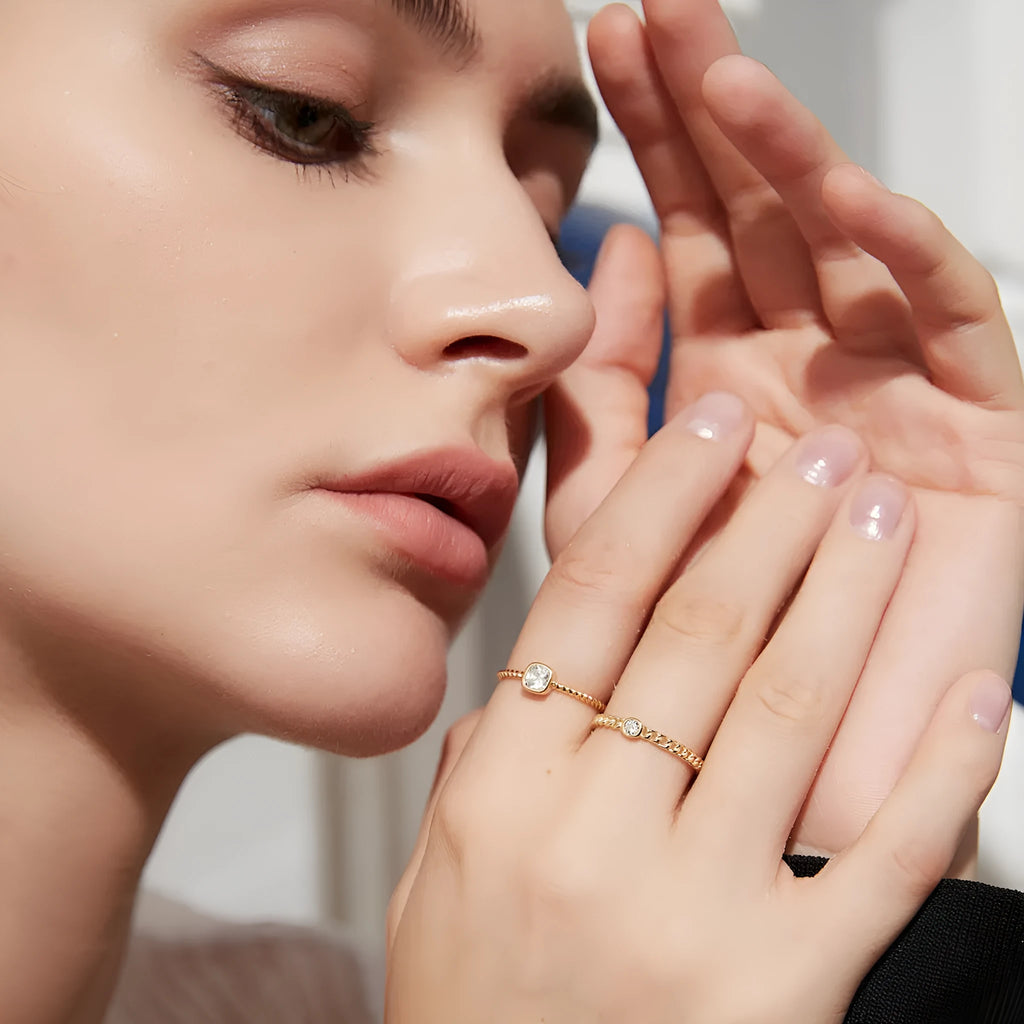 Close-up of 925 silver twist gold ring with geometric chain detail on a neutral background