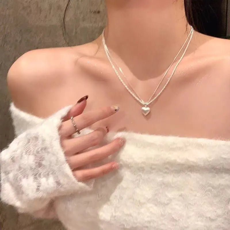 Double-layer heart pendant necklace in brushed silver finish with adjustable chain
