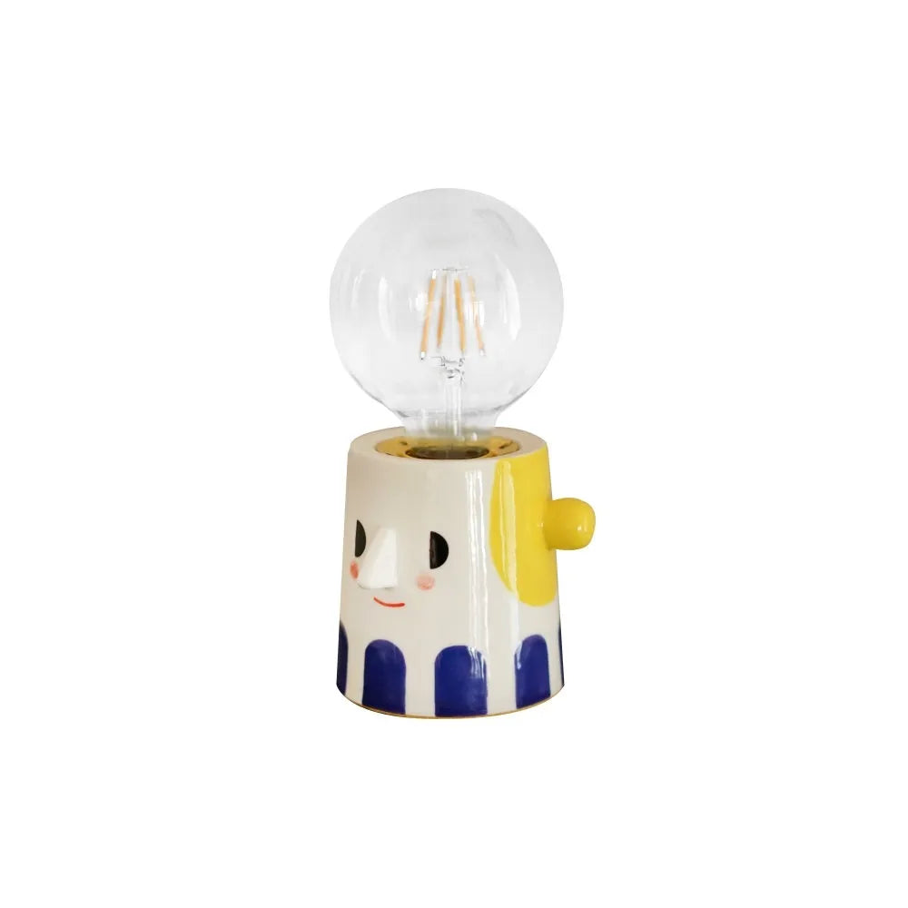 Handmade ceramic bedside lamp with ball headlight colour finish on a table.