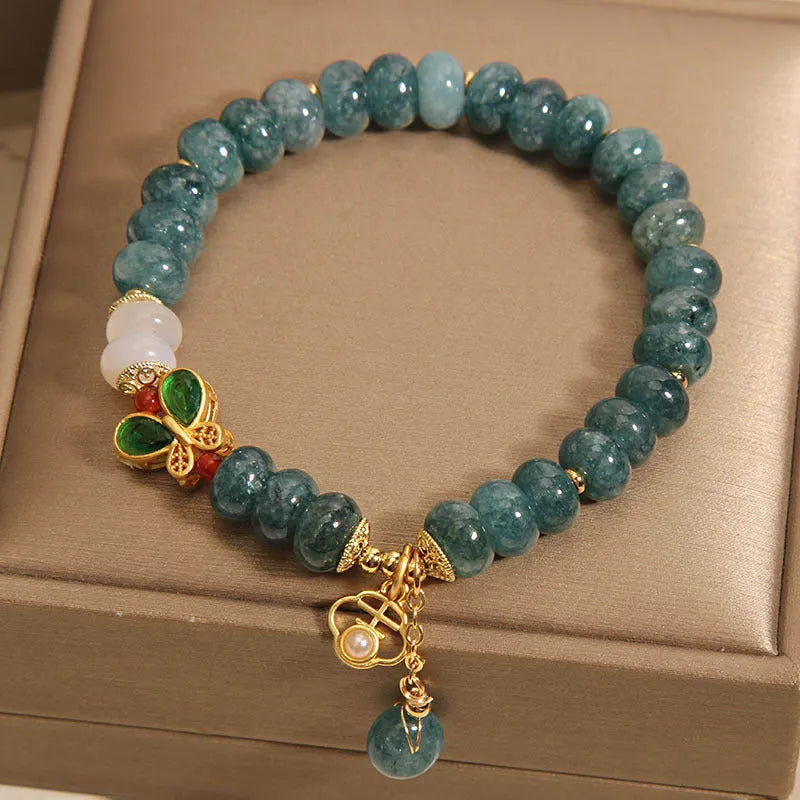 Women's blue water jade and white agate abacus bead bracelet with rhinestones and a butterfly charm on an alloy chain.