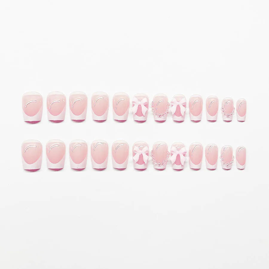 Pack of short white French manicure nail stickers with bow, tulip, and starry sky patterns.