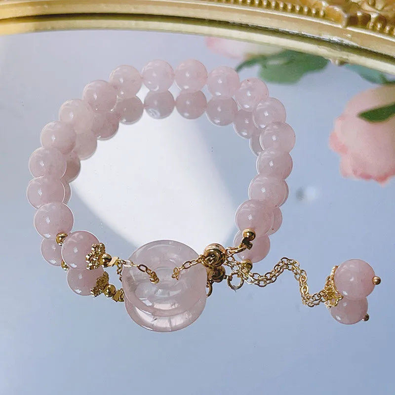 Pink crystal bracelet with peace symbol safety buckle clasp on woman's wrist
