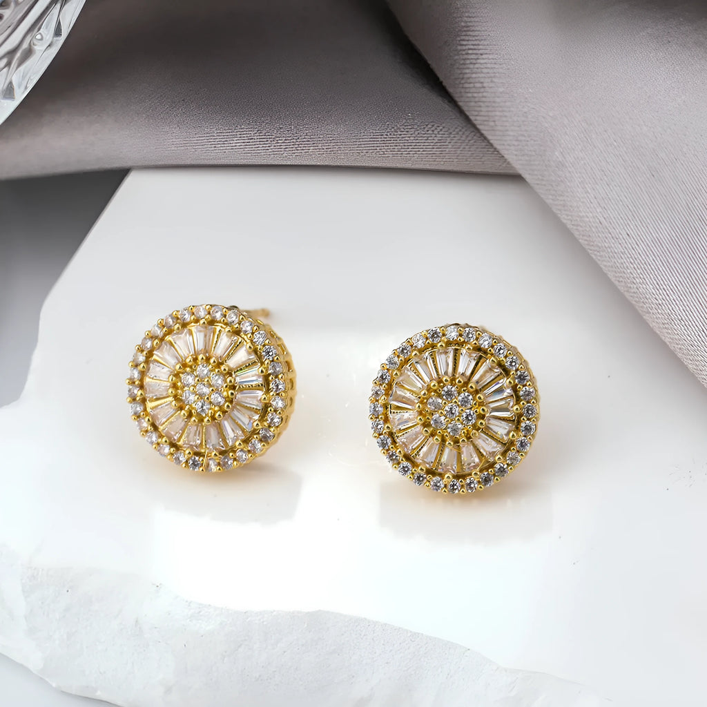 A pair of gold-coloured geometric earrings with a round pattern design, made from copper.