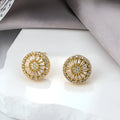 A pair of gold-coloured geometric earrings with a round pattern design, made from copper.