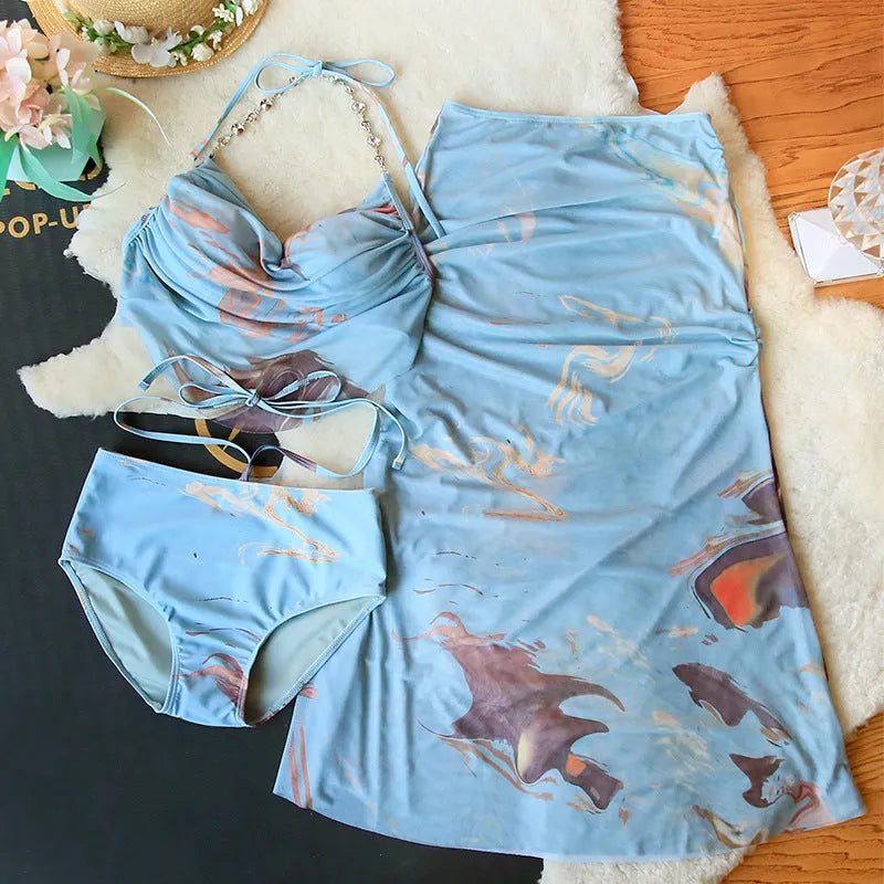 Women's blue printed bikini set with steel support top, pants, and matching skirt laid flat.