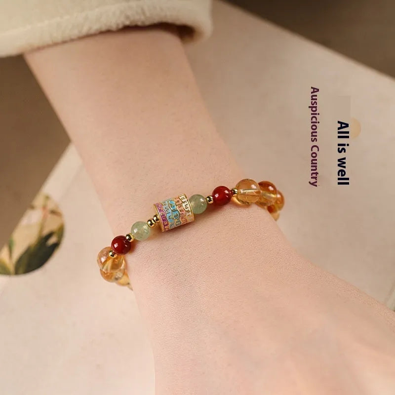 Yellow citrine prayer wheel bracelet with 8mm beads on wrist