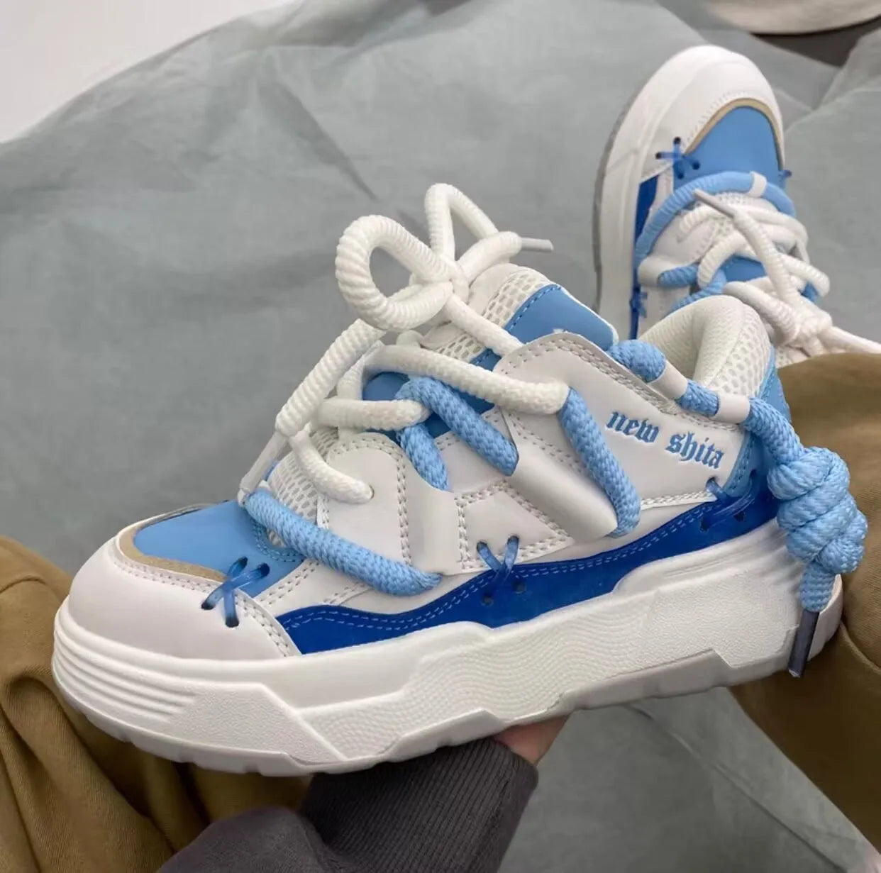 Grey retro clunky sneakers for women with thick sole for height increase and front lace-up closure.