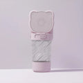 Green 3-in-1 portable pet water bottle with food container and waste bag dispenser, held by its strap.