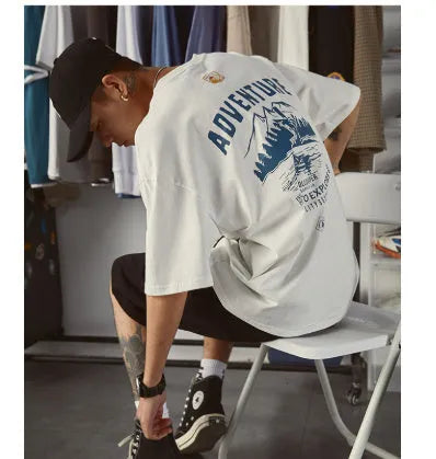 Plus size man modelling a loose fit short-sleeved t-shirt in black, dark grey, or white.