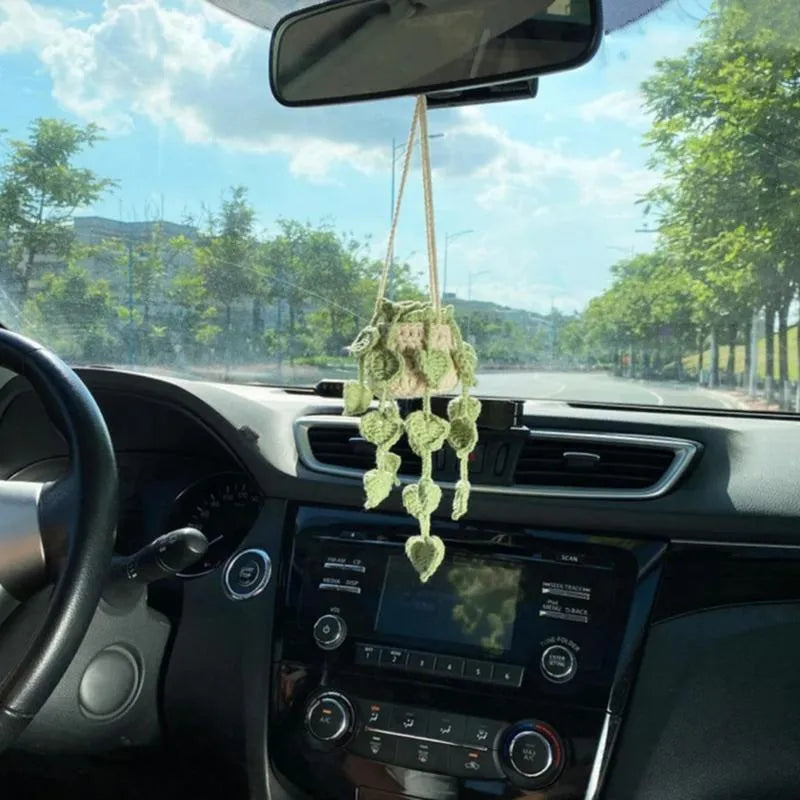 Green and white knitted wool car plant decoration with 25cm hanging rope on a car dashboard