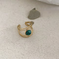 Geometric open ring with a green natural stone set on a titanium steel electroplated band.